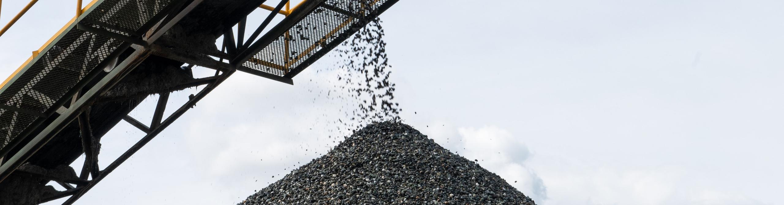 a conveyor belt carrying coking coal and emptying onto a huge pile