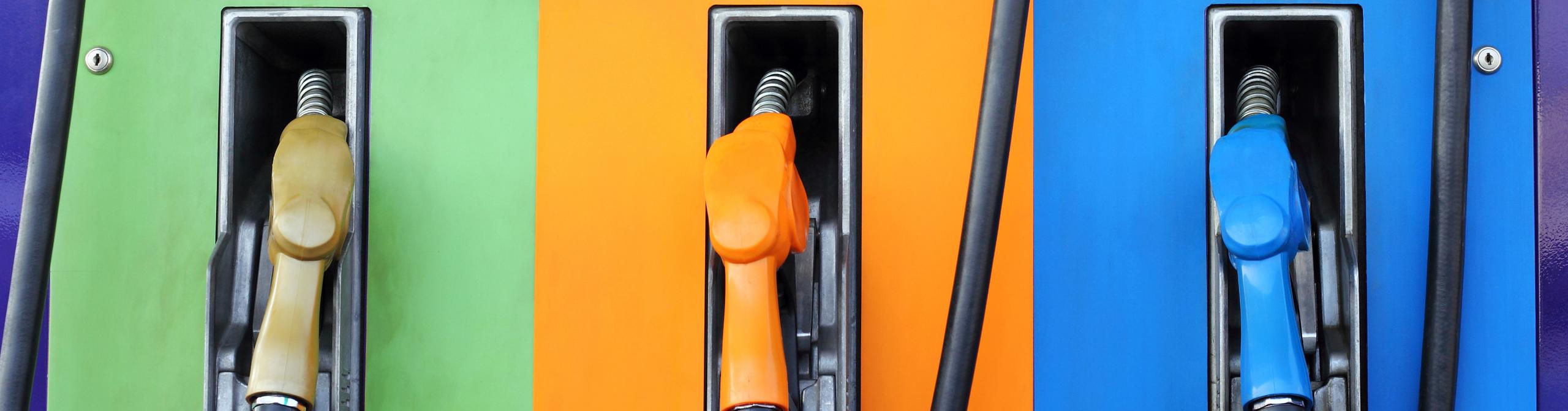 Fuel dispenser machines with green, orange and blue colors. Gasoline pump filling fuel nozzle